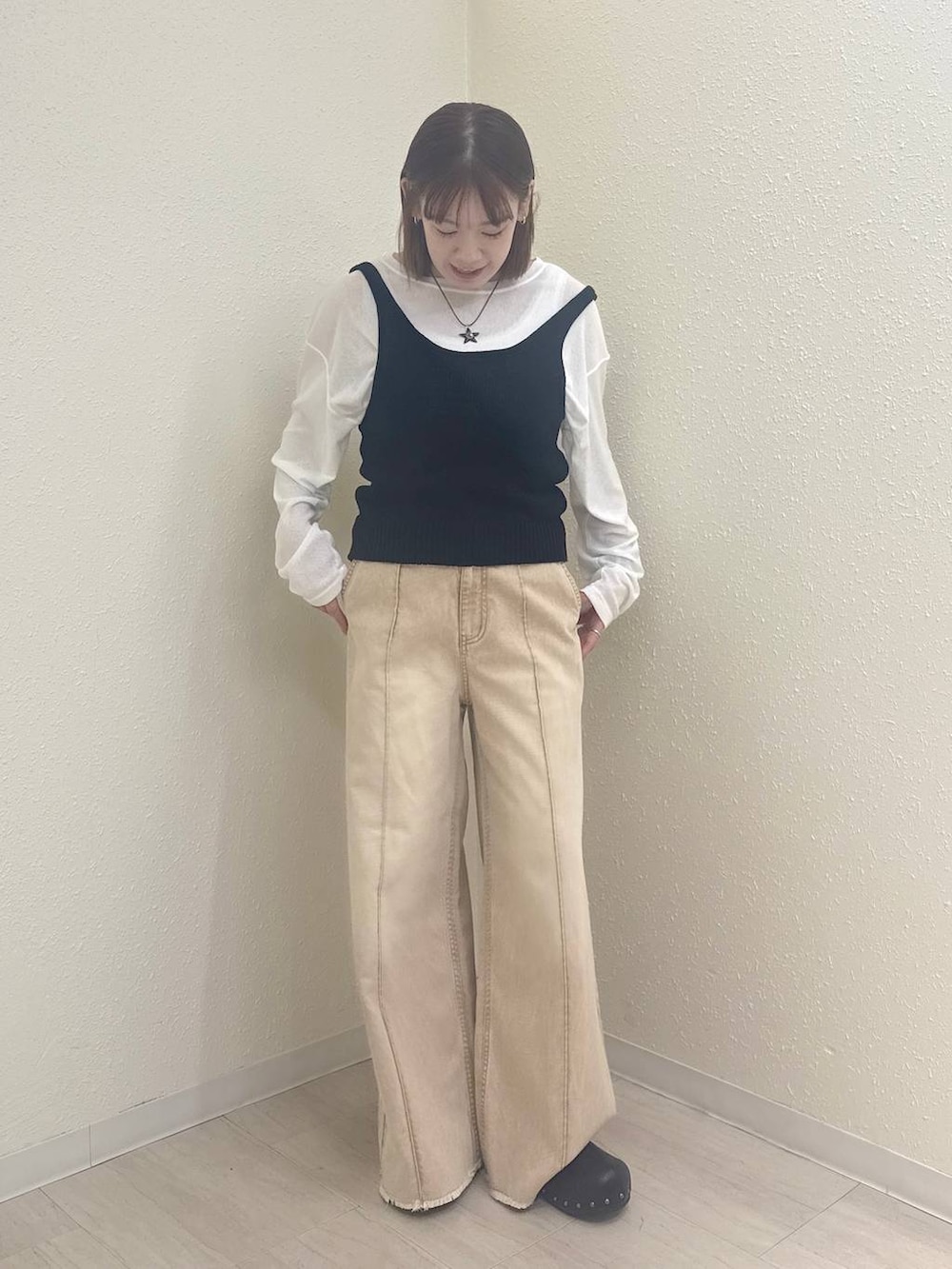 ホワイト系のTシャツ/カットソー、オレンジ系のデニムパンツ、ブラック系のサンダルを着用したレディースの春コーディネートの2枚目の写真