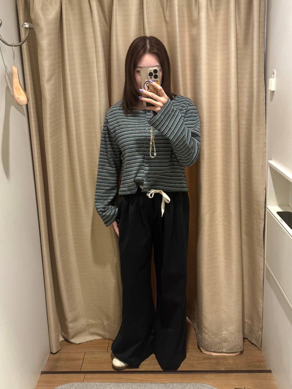 ブラック系のデニムパンツ、グリーン系のカーディガン/ボレロを着用したレディースの春コーディネートの2枚目の写真