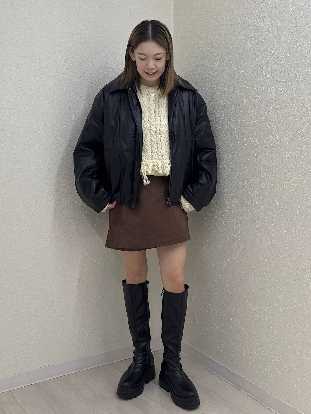 ブラック系のブルゾン、ブラウン系のスカート、ブラック系のブーツを着用したレディースの秋コーディネートの4枚目の写真