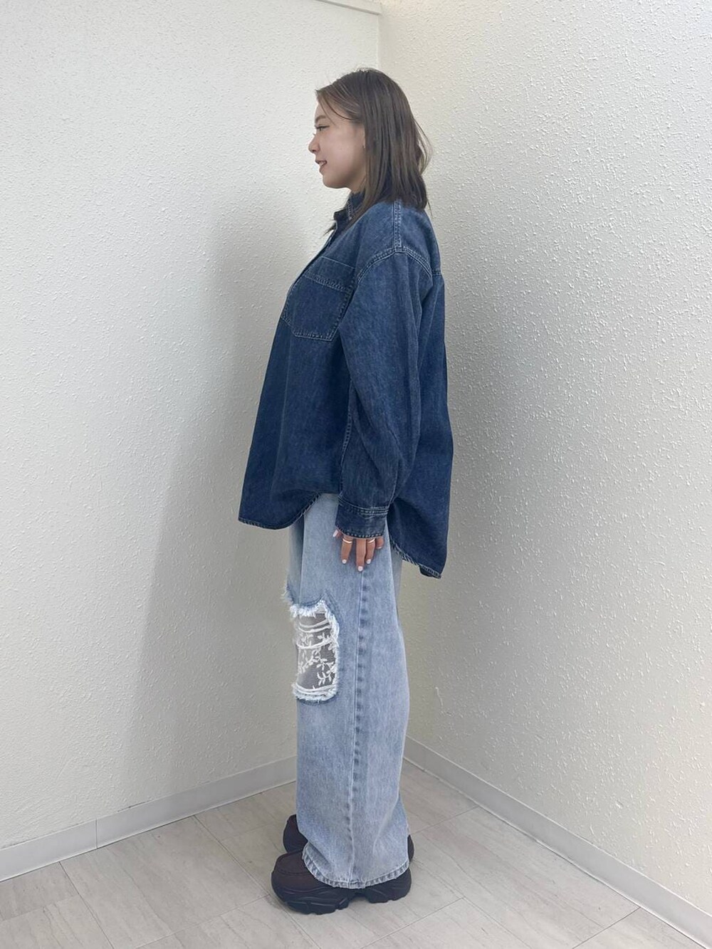 ブルー系のデニムパンツ、ブルー系のシャツ/ブラウス、ブラウン系のローファーを着用したレディースの冬コーディネートの5枚目の写真