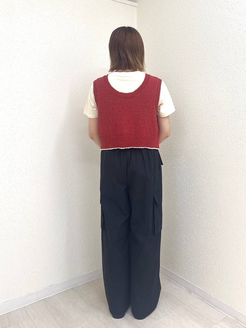 ホワイト系のサンダル、レッド系のベスト、ブラック系のカーゴパンツを着用したレディースの夏コーディネートの4枚目の写真