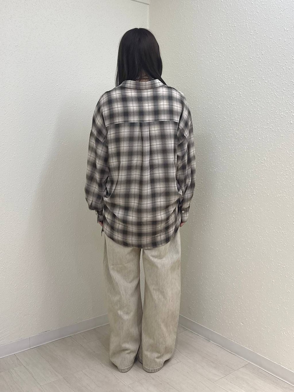 ホワイト系のTシャツ/カットソー、ブラック系のパンプス、ベージュ系のデニムパンツを着用したレディースの春コーディネートの4枚目の写真