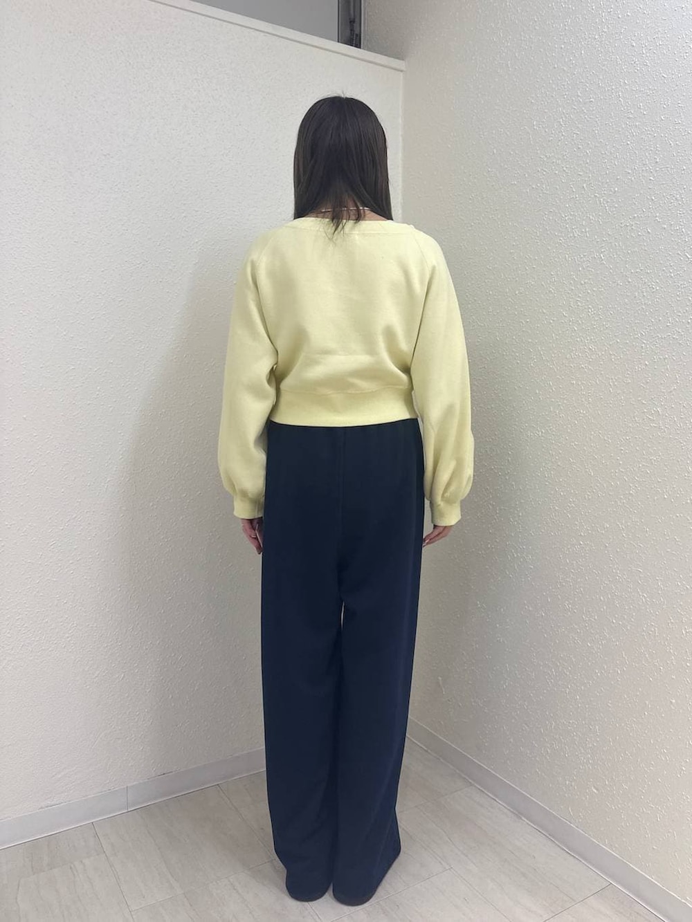 ブラック系のサンダル、ブルー系のスウェットパンツ、イエロー系のスウェットを着用したレディースの冬コーディネートの2枚目の写真