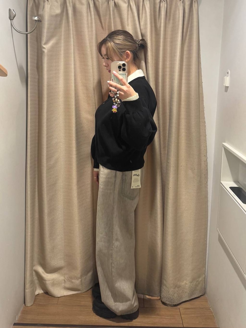 ベージュ系のデニムパンツ、ブラック系のローファー、ブラック系のニット/セーターを着用したレディースの冬コーディネートの2枚目の写真