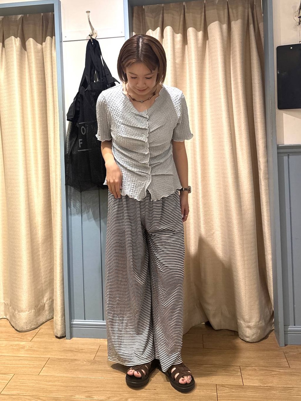 ブルー系のカーディガン/ボレロ、ホワイト系のその他パンツ、ブラウン系のサンダルを着用したレディースの夏コーディネートの2枚目の写真