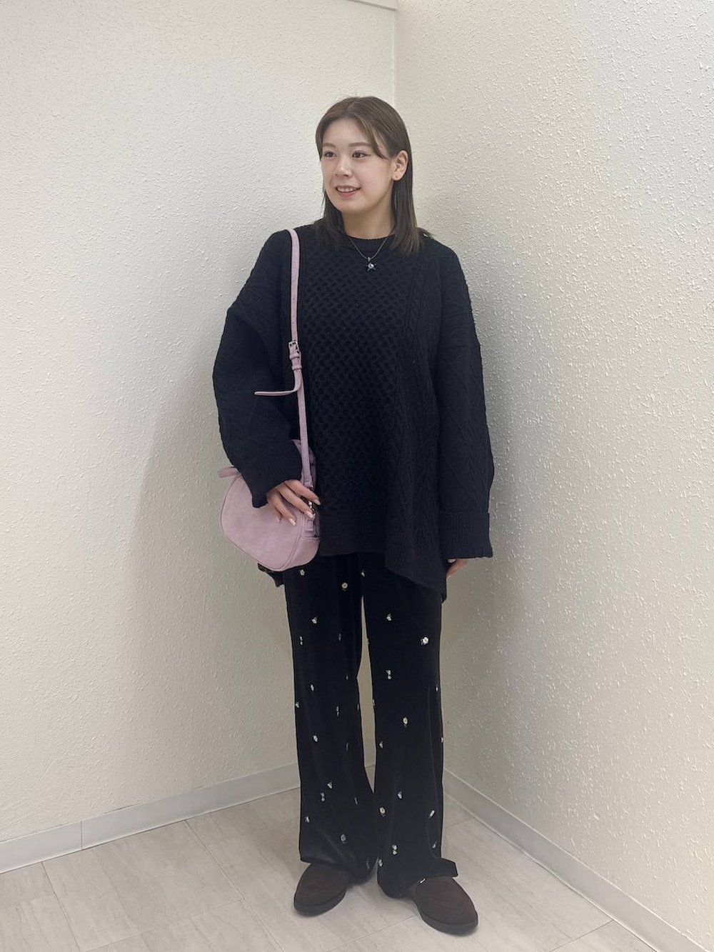 ブラウン系のローファー、ピンク系のボストンバッグ、ブラック系のニット/セーターを着用したレディースの冬コーディネートの2枚目の写真