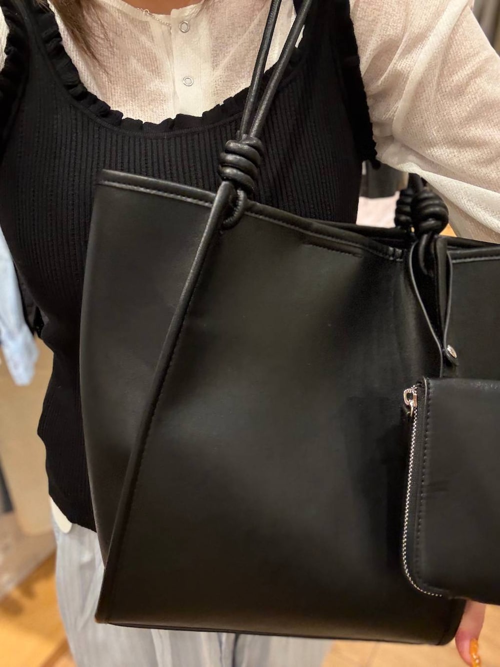 ベージュ系のスウェットパンツ、ブルー系のカーディガン/ボレロ、ブラック系のトートバッグを着用したレディースの春コーディネートの2枚目の写真