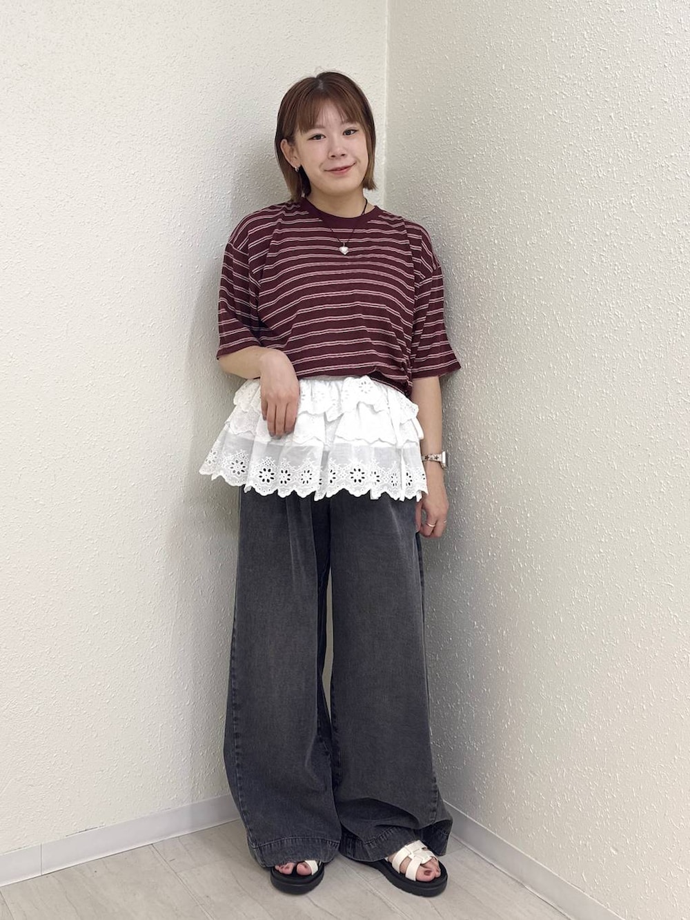 ブラック系のデニムパンツ、ホワイト系のサンダル、ブラウン系のTシャツ/カットソーを着用したレディースの春コーディネートの3枚目の写真