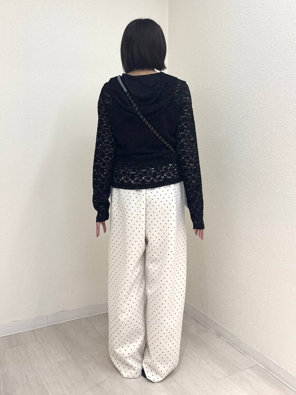 ブルー系のショルダーバッグ、ブラック系のTシャツ/カットソー、ホワイト系のスウェットパンツを着用したレディースの秋コーディネートの2枚目の写真
