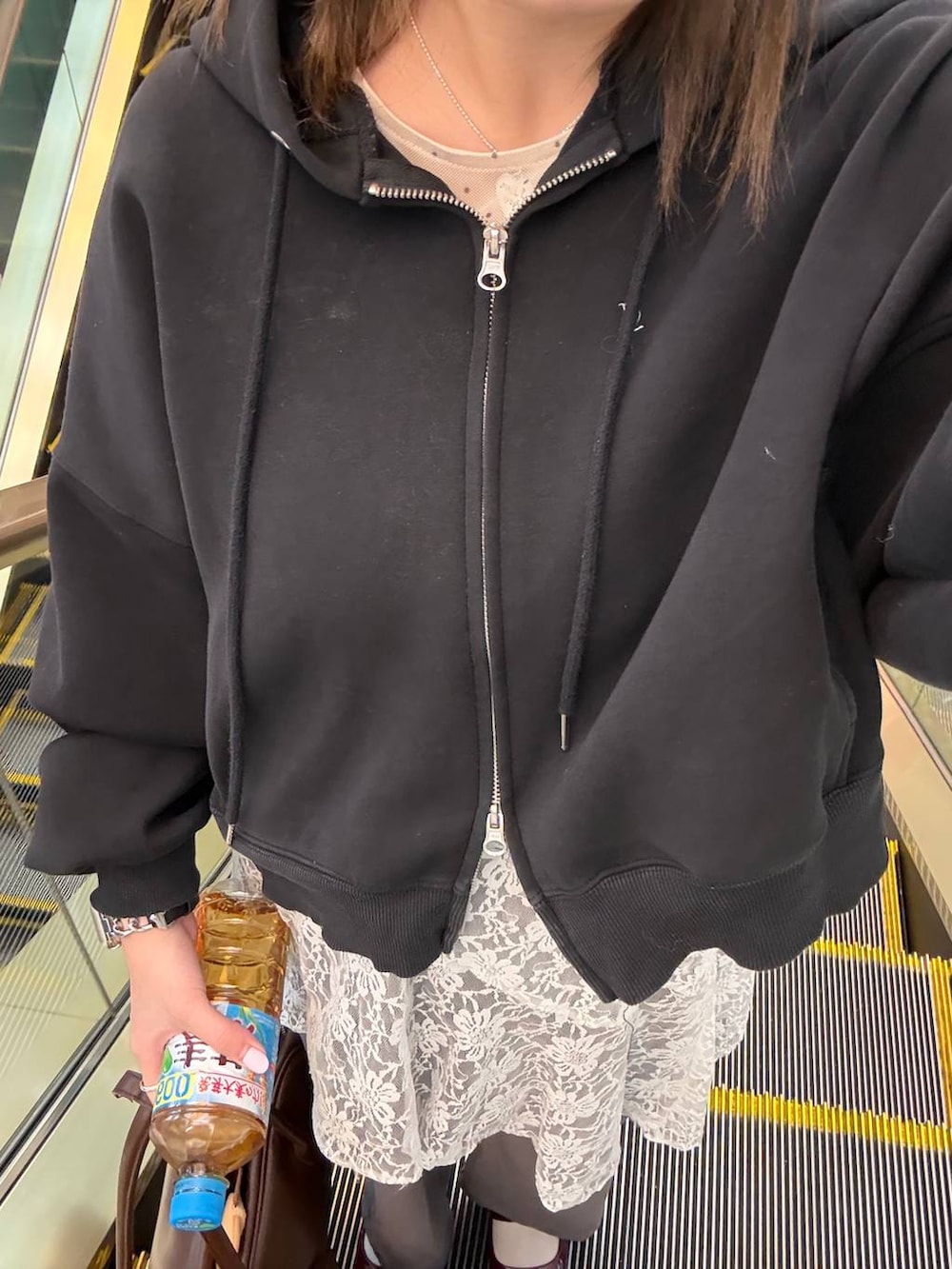 グレー系のその他パンツ、ホワイト系のスカート、ブラック系のパーカーを着用したレディースの冬コーディネートの2枚目の写真