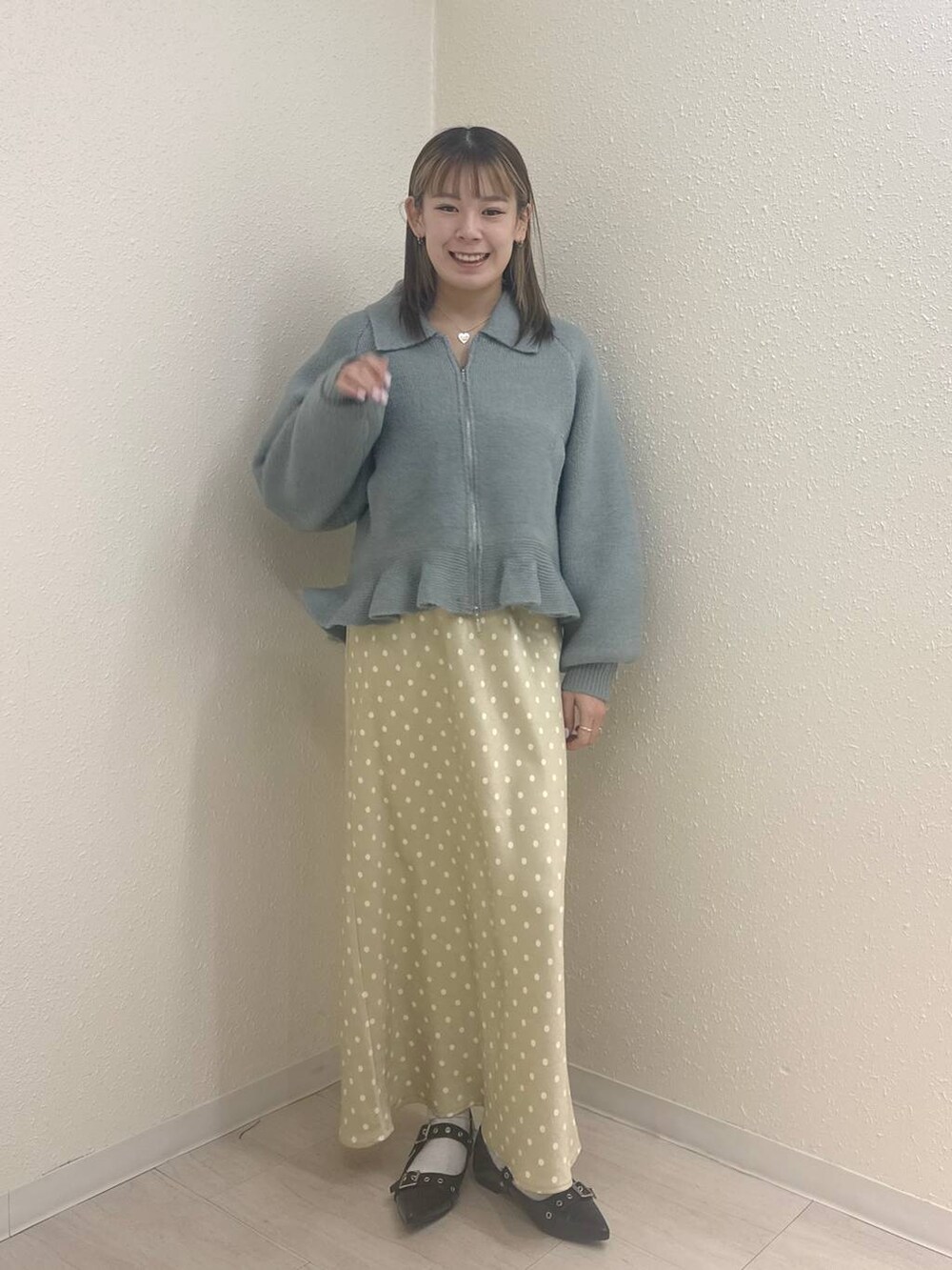 ベージュ系のスカート、グリーン系のブルゾンを着用したレディースの春コーディネートの2枚目の写真