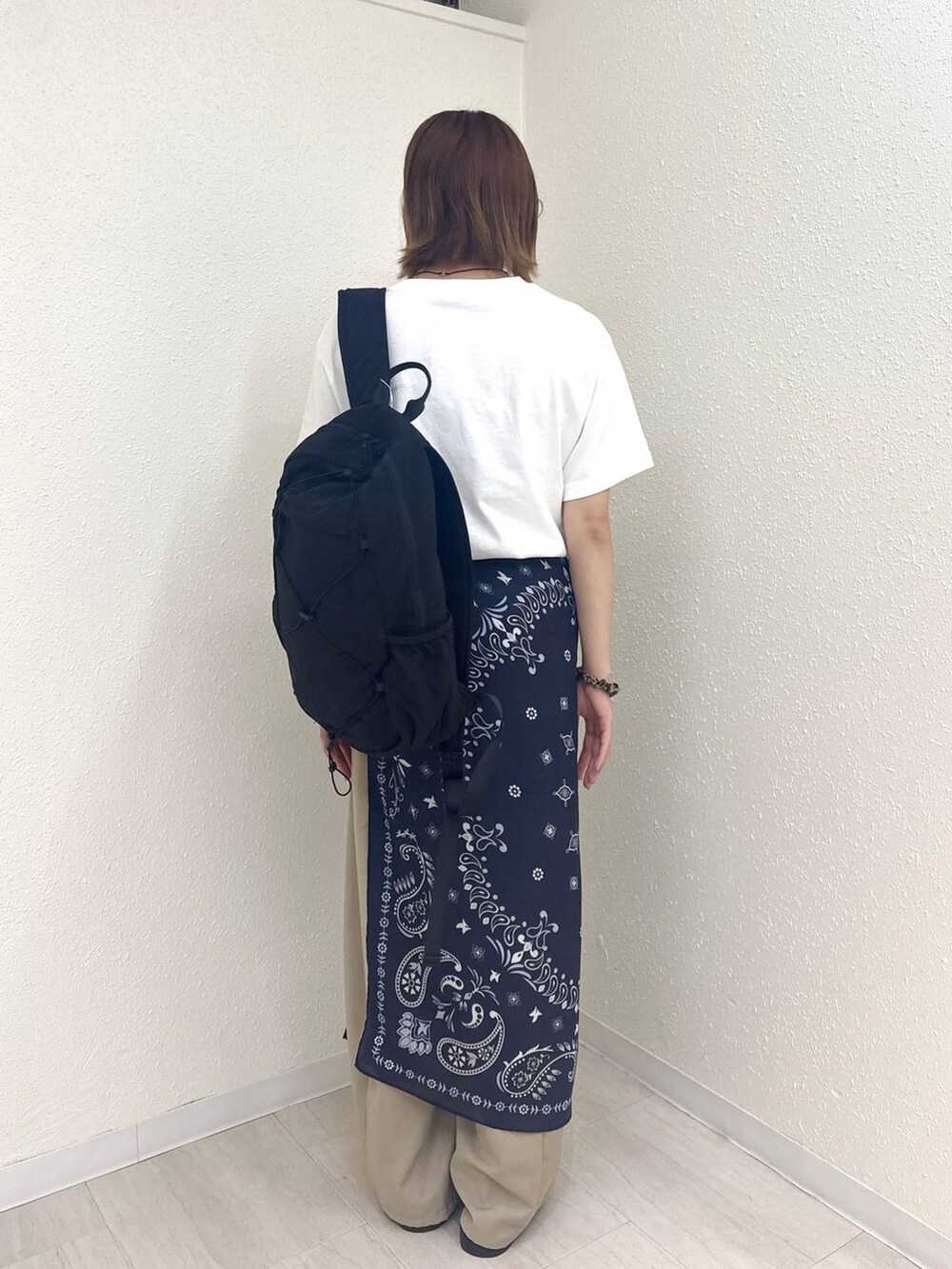 ベージュ系のその他パンツ、ブラウン系のサンダル、ホワイト系のTシャツ/カットソーを着用したレディースの夏コーディネートの4枚目の写真