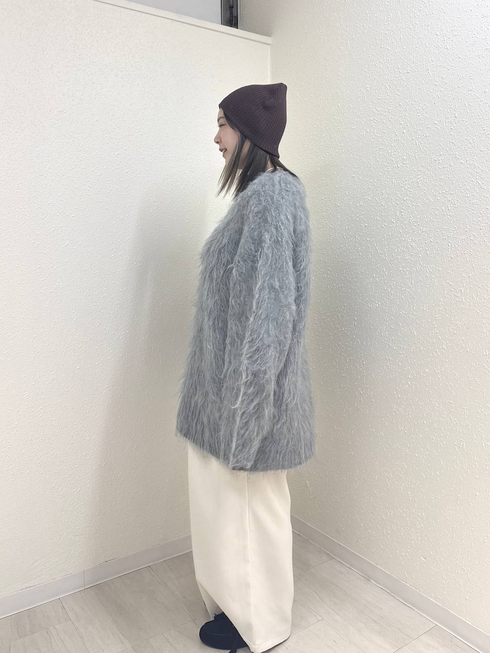 ホワイト系のその他パンツ、ブラック系のモカシン/デッキシューズ、グレー系のニット/セーターを着用したレディースの冬コーディネートの3枚目の写真