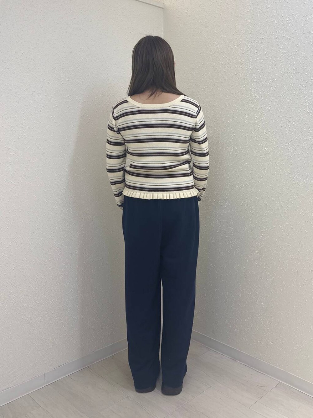 ブラウン系のローファー、ブルー系のスウェットパンツ、ホワイト系のニット/セーターを着用したレディースの冬コーディネートの2枚目の写真