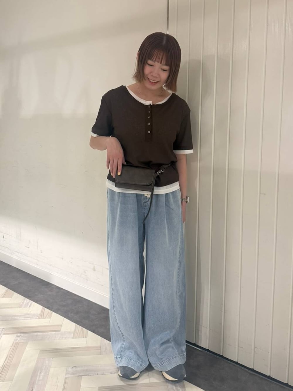 ブルー系のデニムパンツ、ブラウン系のTシャツ/カットソー、ブラウン系のボディバッグ/ウエストポーチを着用したレディースの春コーディネートの3枚目の写真