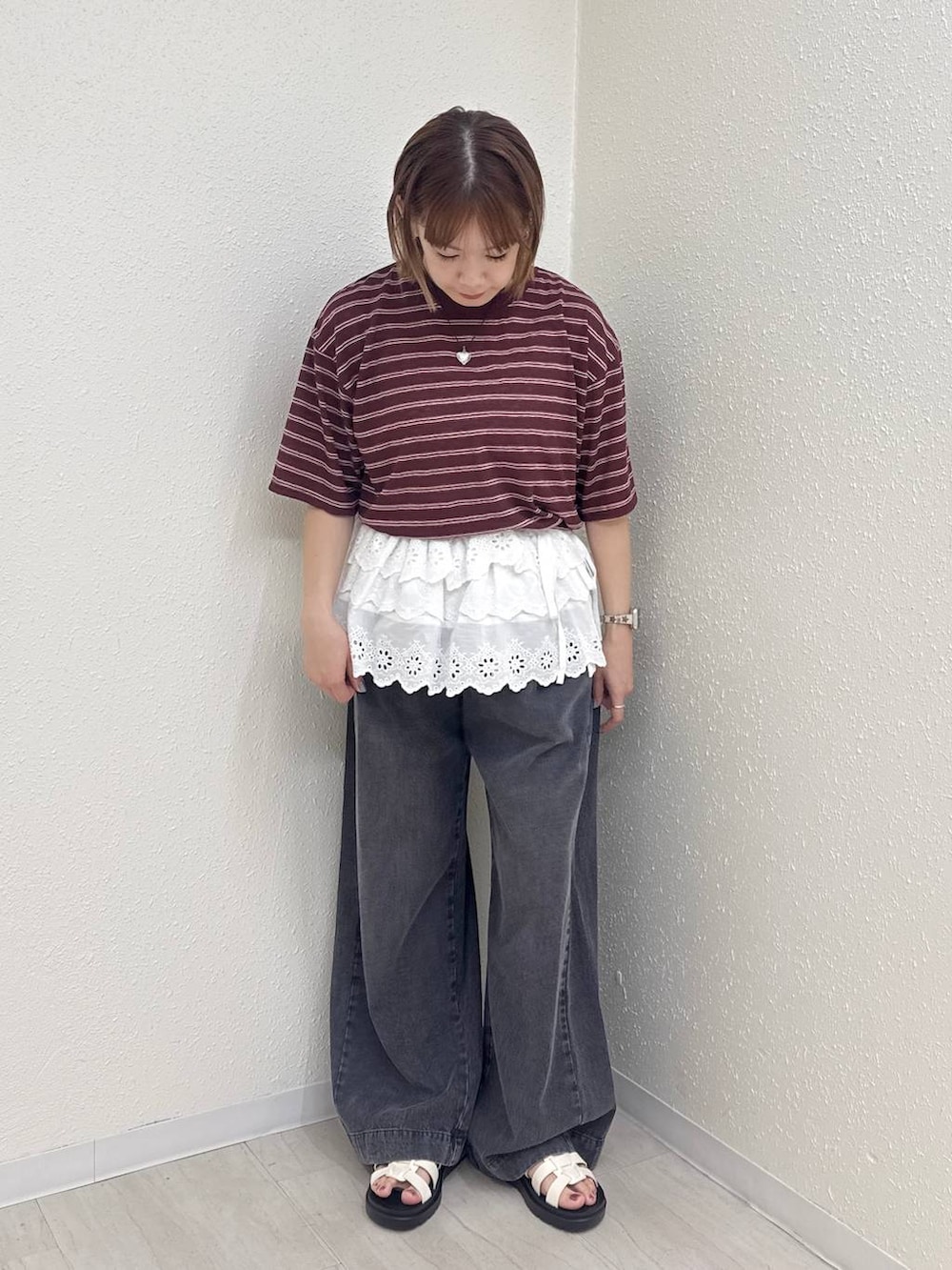 ブラック系のデニムパンツ、ホワイト系のサンダル、ブラウン系のTシャツ/カットソーを着用したレディースの春コーディネートの2枚目の写真
