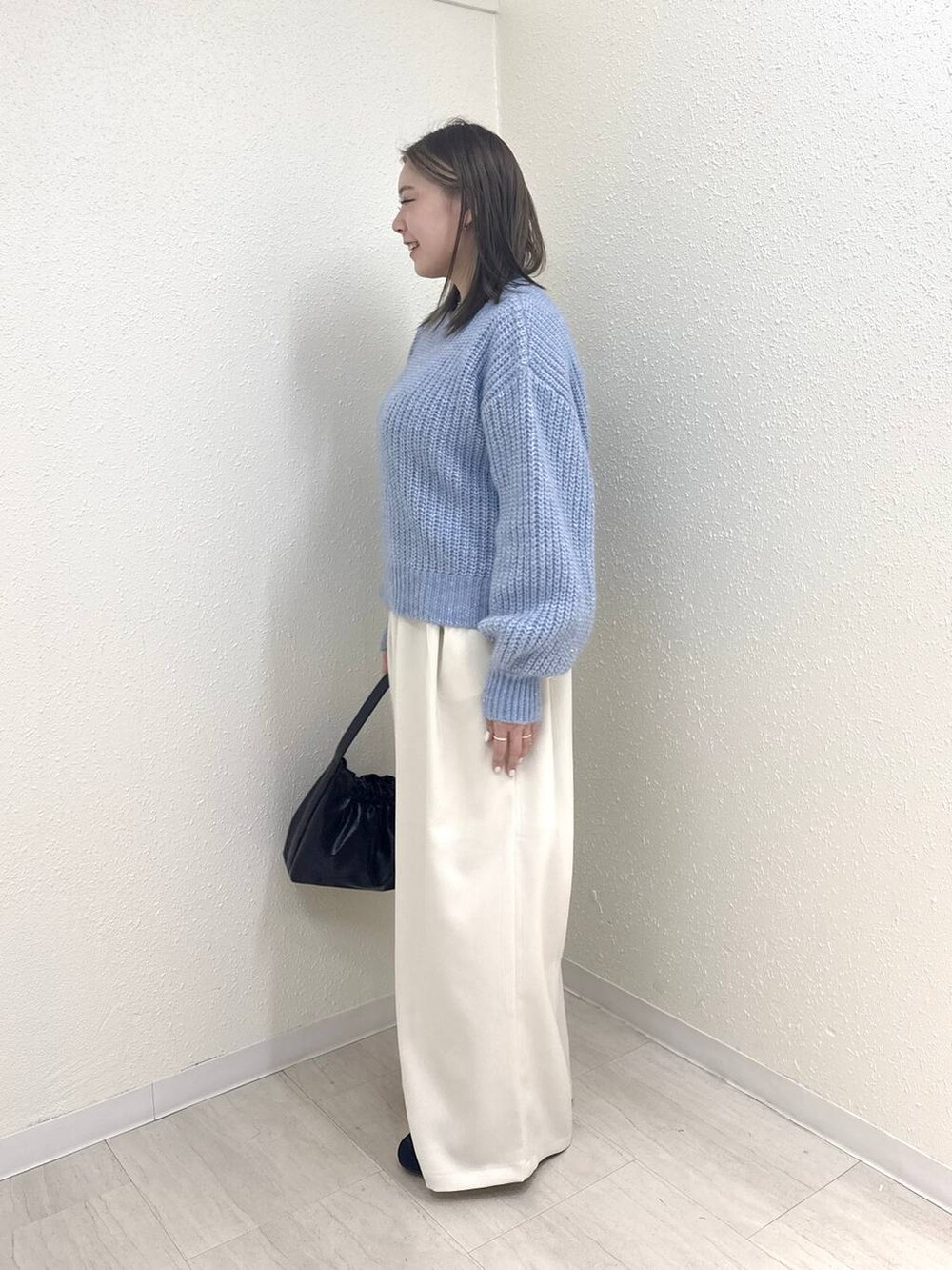 ホワイト系のその他パンツ、ブルー系のニット/セーター、ブラック系のショルダーバッグを着用したレディースの冬コーディネートの2枚目の写真