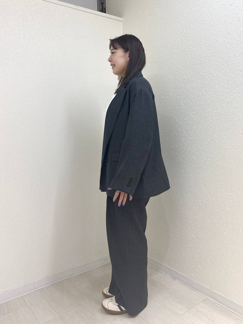 グレー系のテーラードジャケット、グレー系のデニムパンツ、ホワイト系のTシャツ/カットソーを着用したレディースの春コーディネートの4枚目の写真