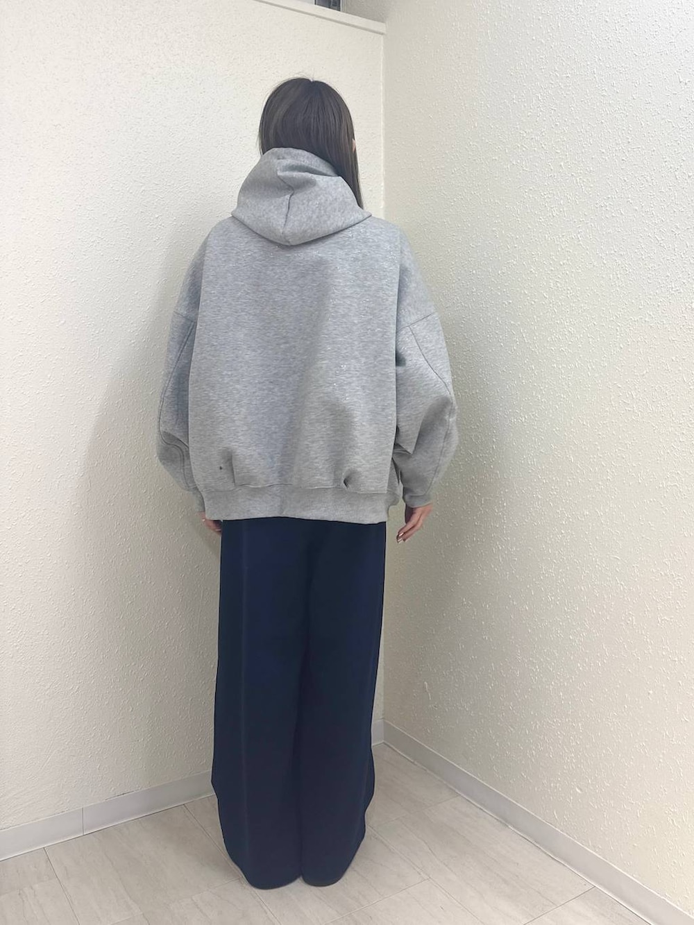 グレー系のパーカー、ブラック系のサンダル、ブルー系のスウェットパンツを着用したレディースの冬コーディネートの3枚目の写真