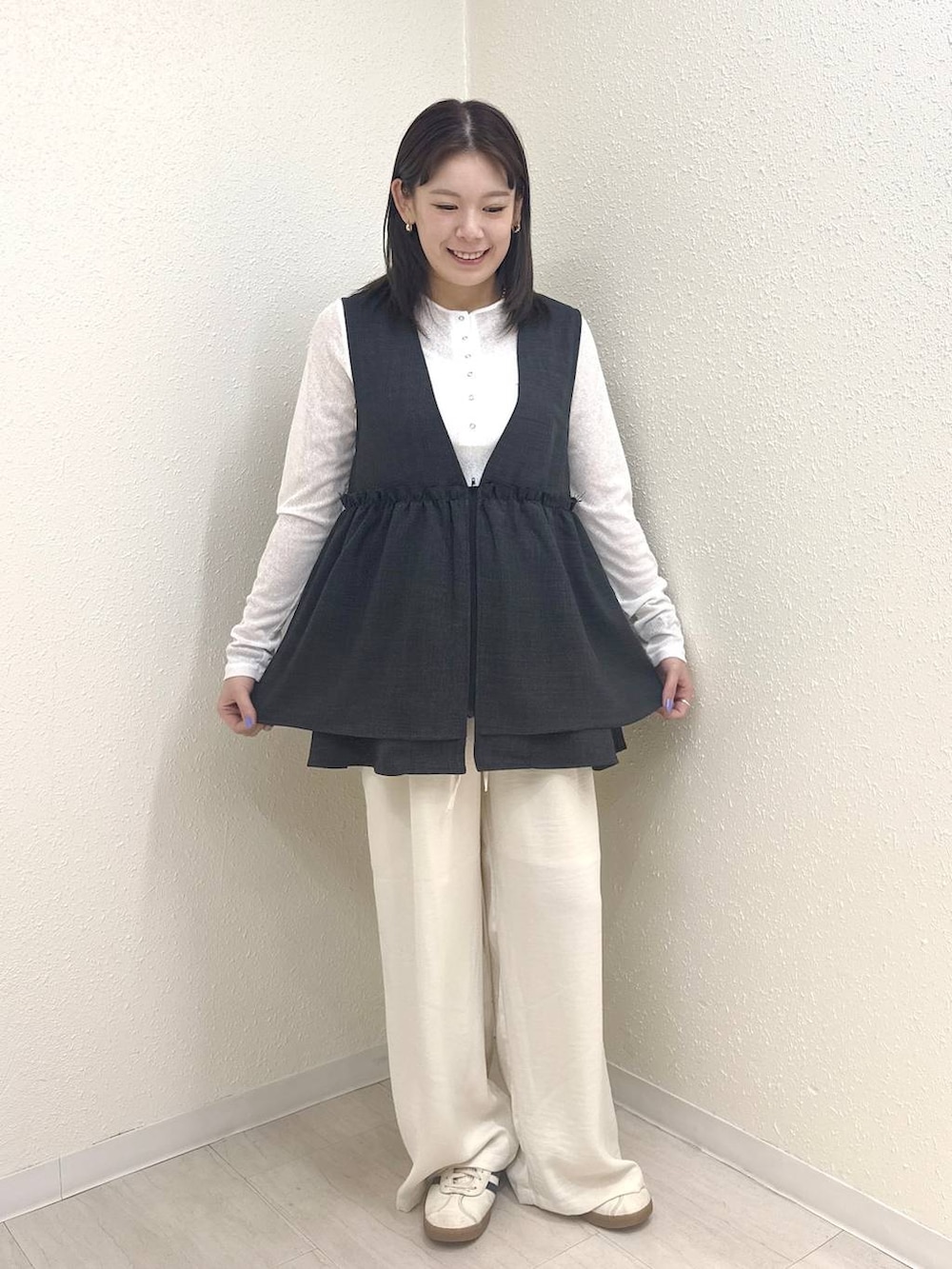 グレー系のベスト、ホワイト系のTシャツ/カットソー、ホワイト系のその他パンツを着用したレディースの春コーディネートの2枚目の写真