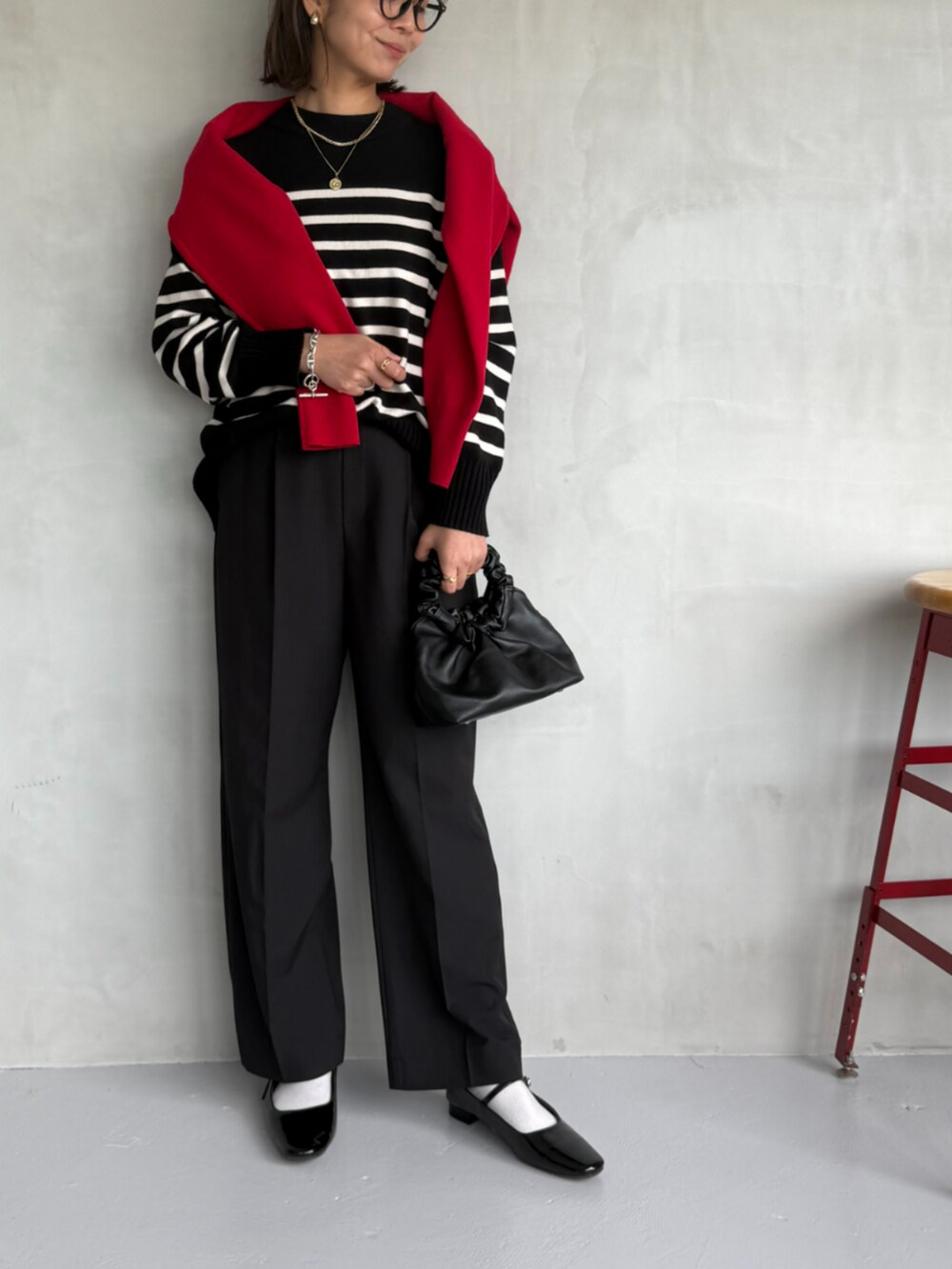 ブラック系のスラックス、ブラック系のニット/セーター、レッド系のニット/セーターを着用したレディースの秋コーディネートの2枚目の写真