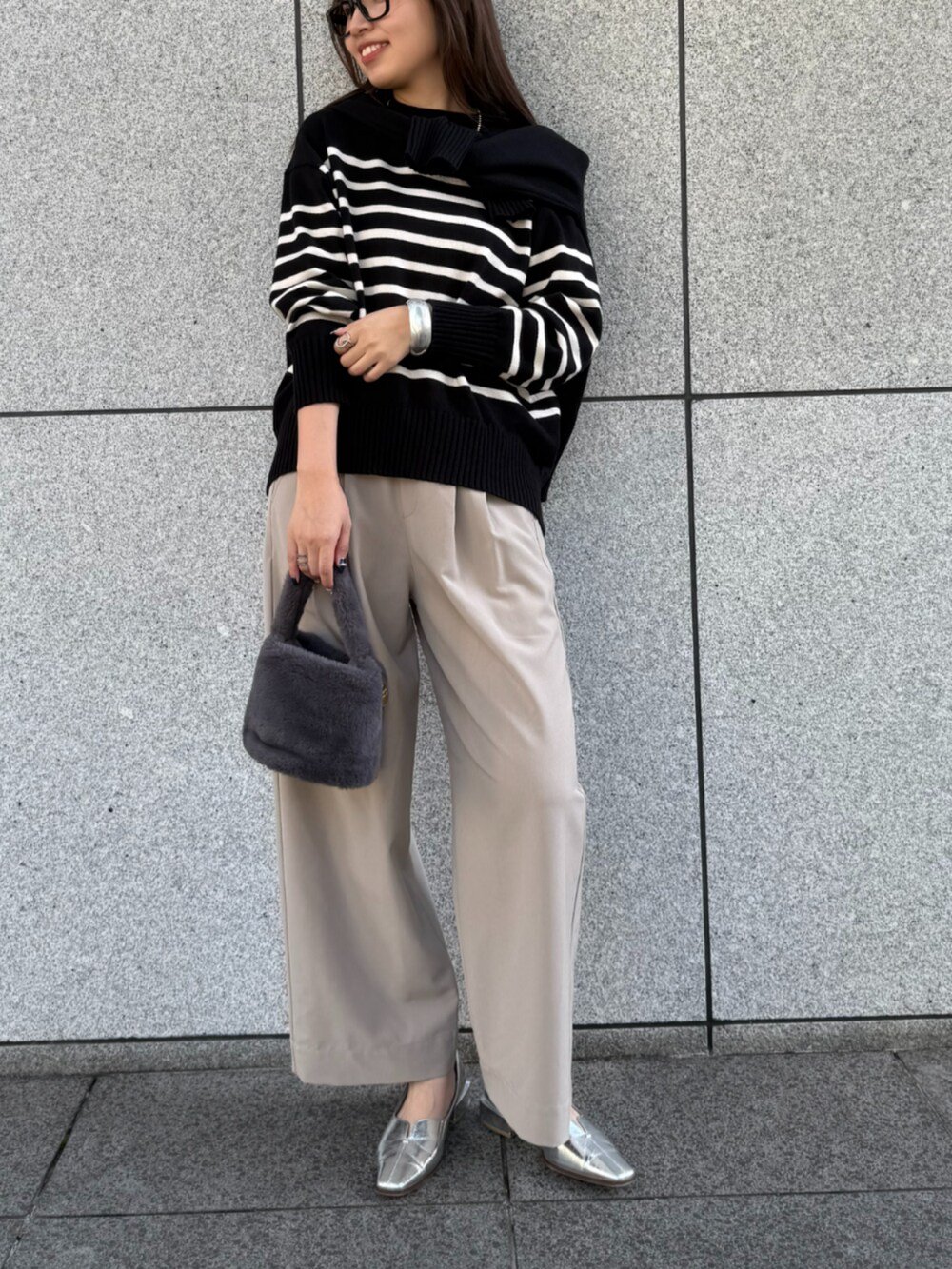 ブラウン系のスラックス、ブラック系のニット/セーター、ブラック系のニット/セーターを着用したレディースの秋コーディネートの2枚目の写真