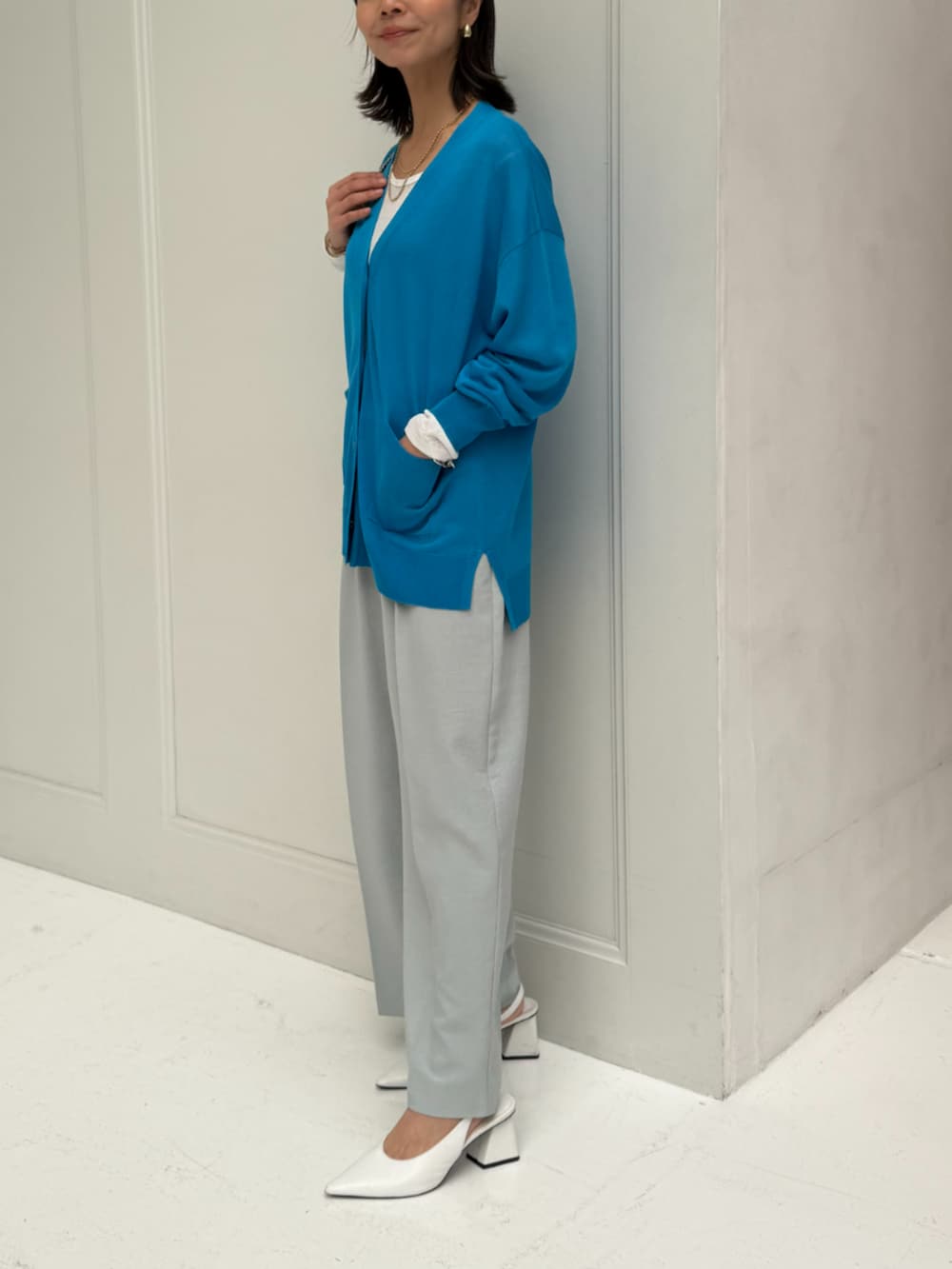 ホワイト系のTシャツ/カットソー、グリーン系のスラックス、ブルー系のカーディガン/ボレロを着用したレディースの春コーディネートの2枚目の写真