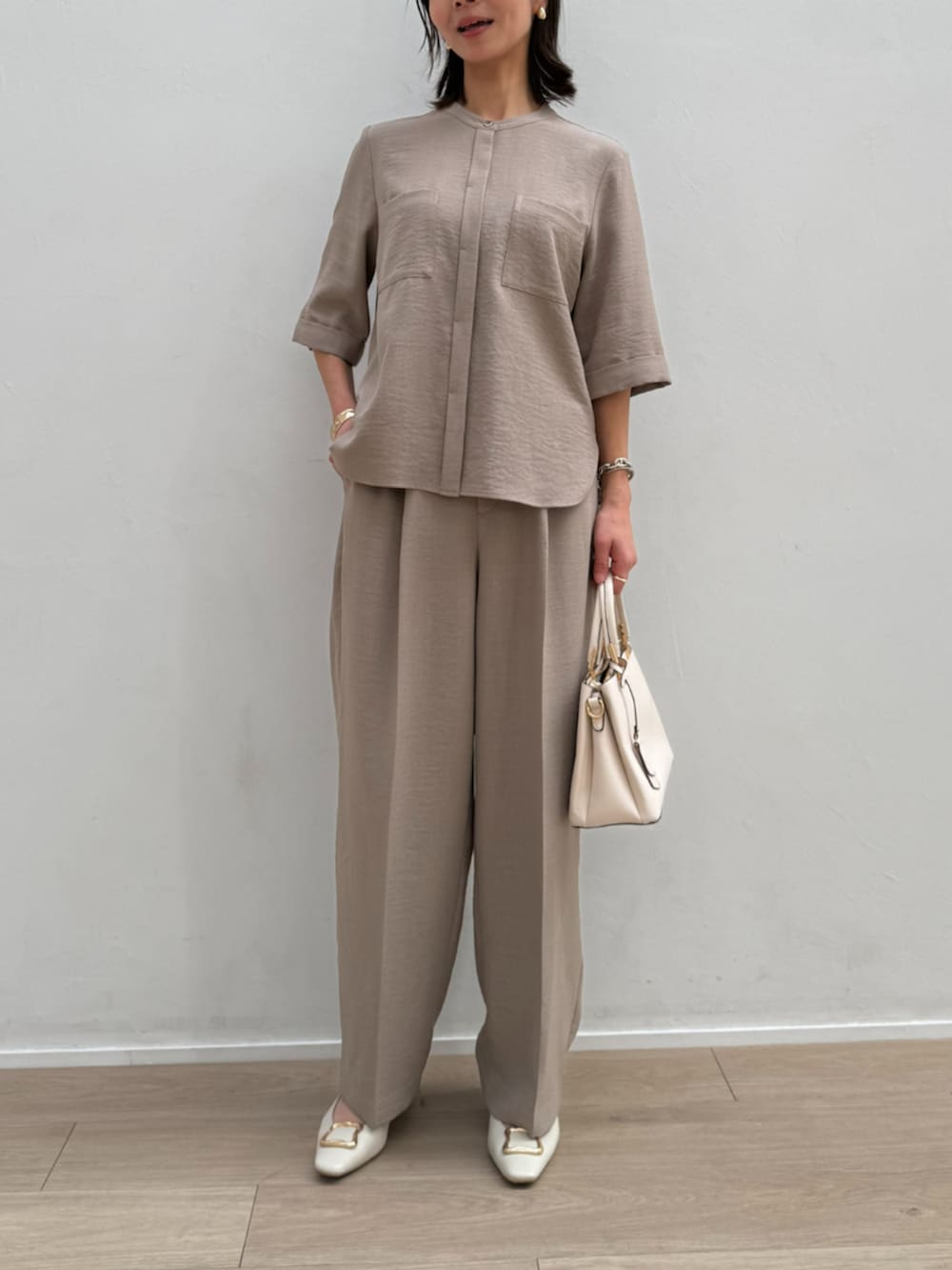 ブラウン系のシャツ/ブラウス、ブラウン系のスラックスを着用したレディースの春コーディネートの2枚目の写真
