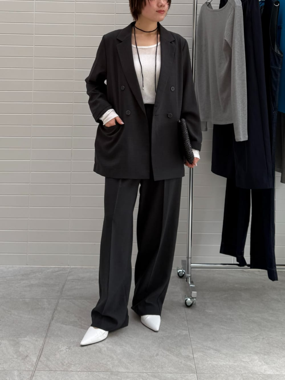 グレー系のテーラードジャケット、グレー系のスラックス、ホワイト系のTシャツ/カットソーを着用したレディースの春コーディネートの2枚目の写真