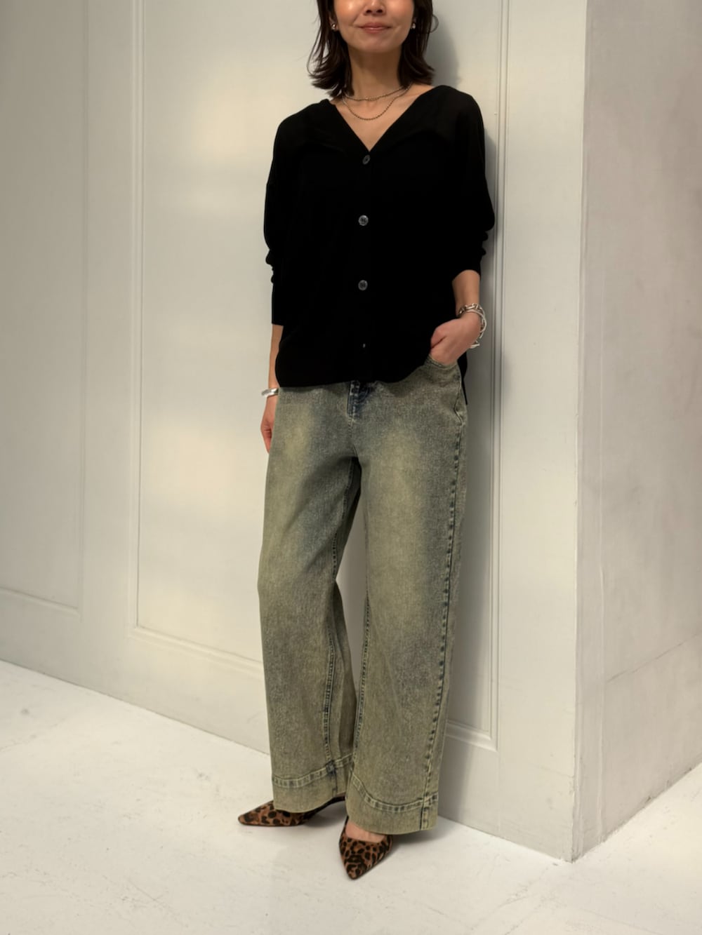 ブラック系のカーディガン/ボレロ、ブルー系のデニムパンツを着用したレディースの春コーディネートの2枚目の写真