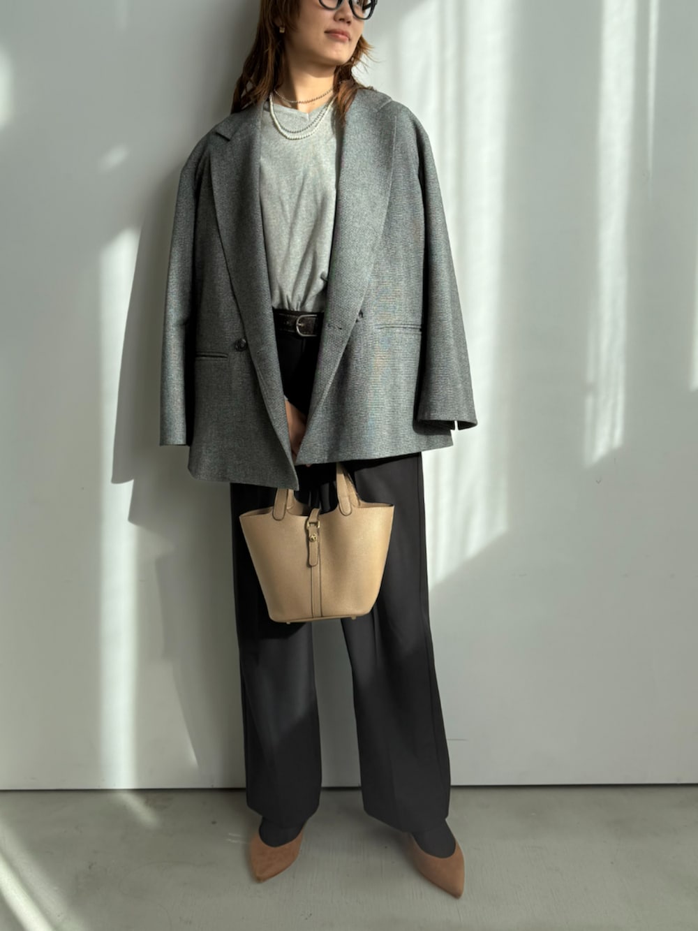 グレー系のニット/セーター、ブラック系のスラックス、グレー系のテーラードジャケットを着用したレディースの冬コーディネートの2枚目の写真