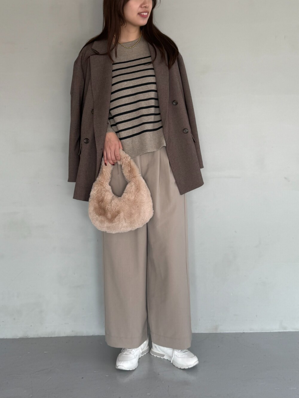 ブラウン系のスラックス、ブラウン系のテーラードジャケット、ブラウン系のニット/セーターを着用したレディースの秋コーディネートの2枚目の写真