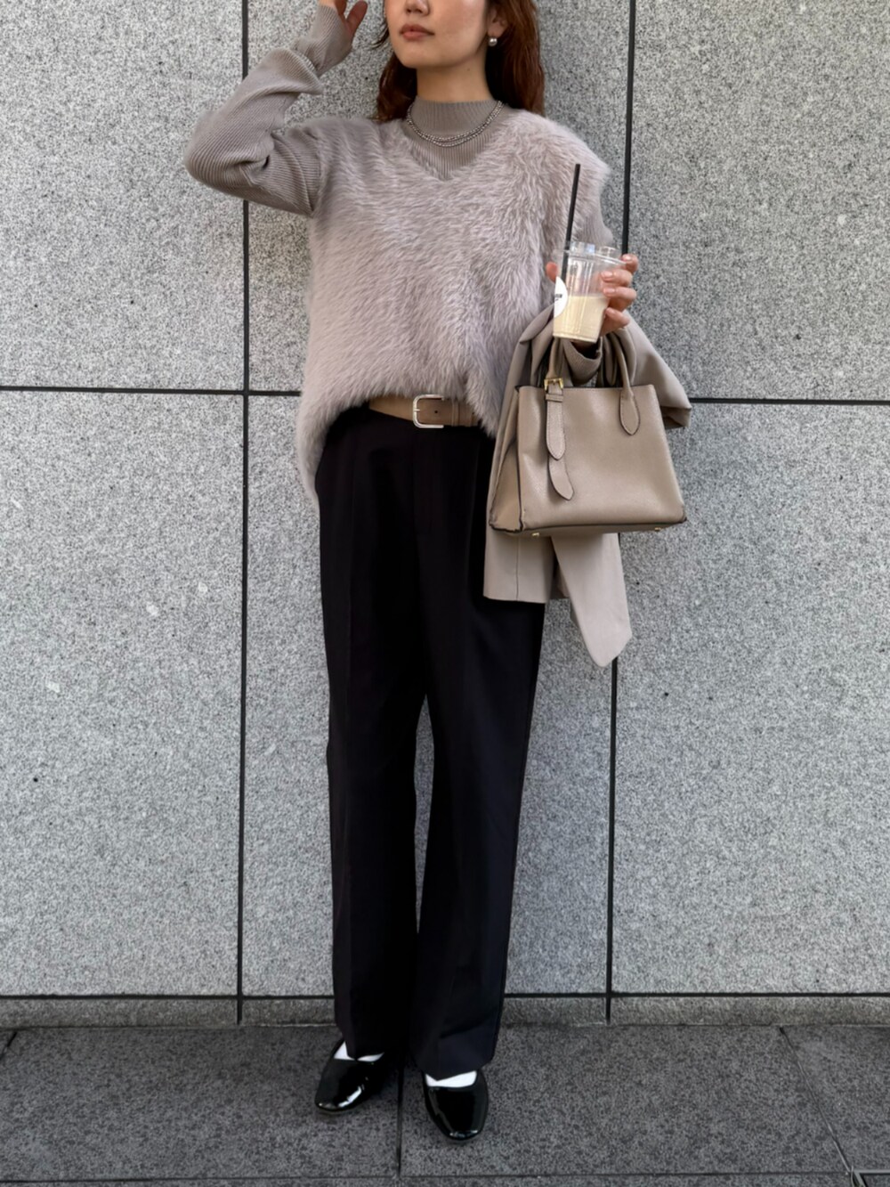 ブラック系のスラックス、ベージュ系のニット/セーターを着用したレディースの秋コーディネートの2枚目の写真