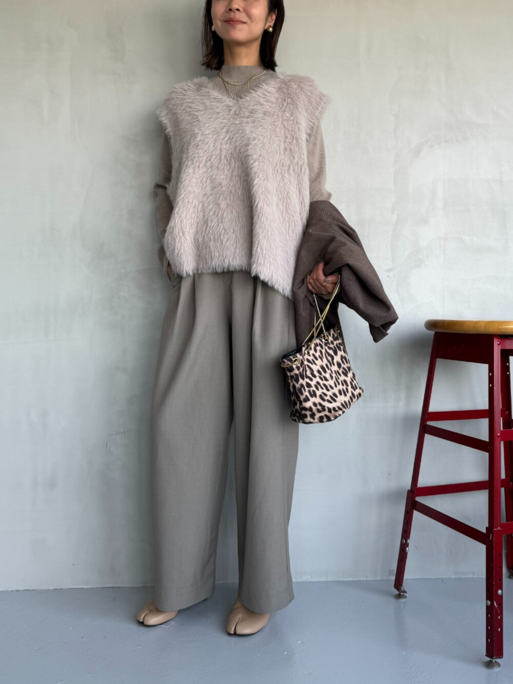 ベージュ系のスラックス、ベージュ系のニット/セーター、ブラウン系のテーラードジャケットを着用したレディースの秋コーディネートの2枚目の写真