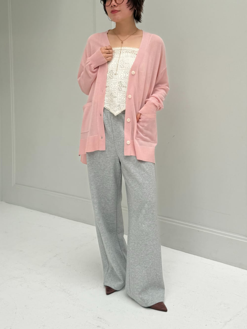 ピンク系のカーディガン/ボレロ、グレー系のスウェットパンツを着用したレディースの春コーディネートの2枚目の写真