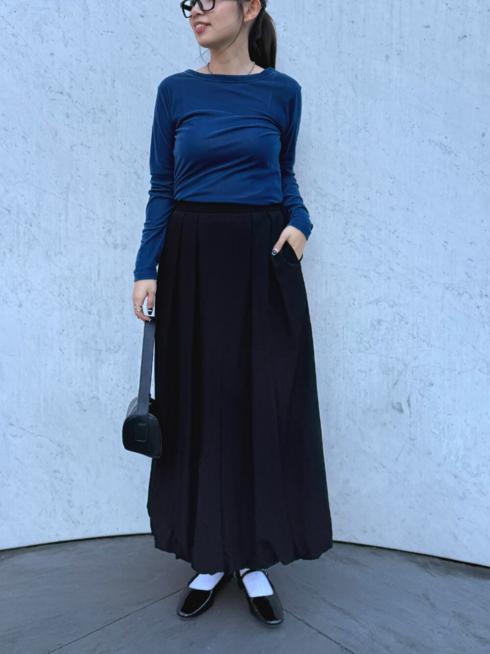 ブラック系のその他アウター、ブラック系のスカート、ブルー系のTシャツ/カットソーを着用したレディースの秋コーディネートの2枚目の写真