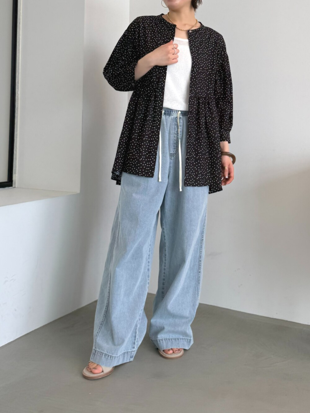 ブルー系のデニムパンツ、ブラック系のシャツ/ブラウスを着用したレディースの春コーディネートの2枚目の写真
