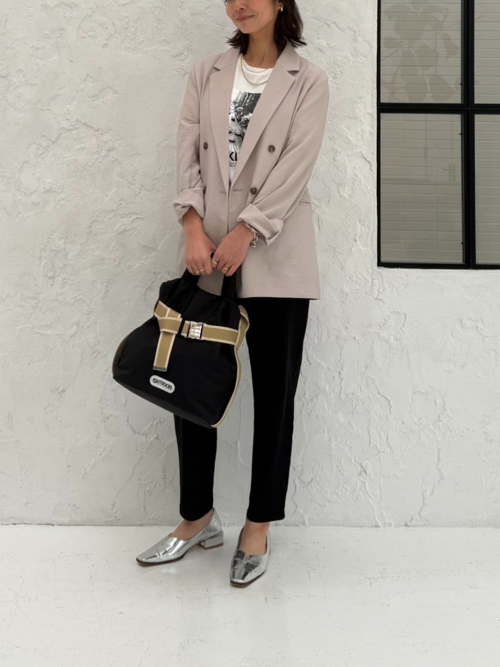ブラック系のその他パンツ、ブラック系のトートバッグ、ベージュ系のテーラードジャケットを着用したレディースの春コーディネートの2枚目の写真