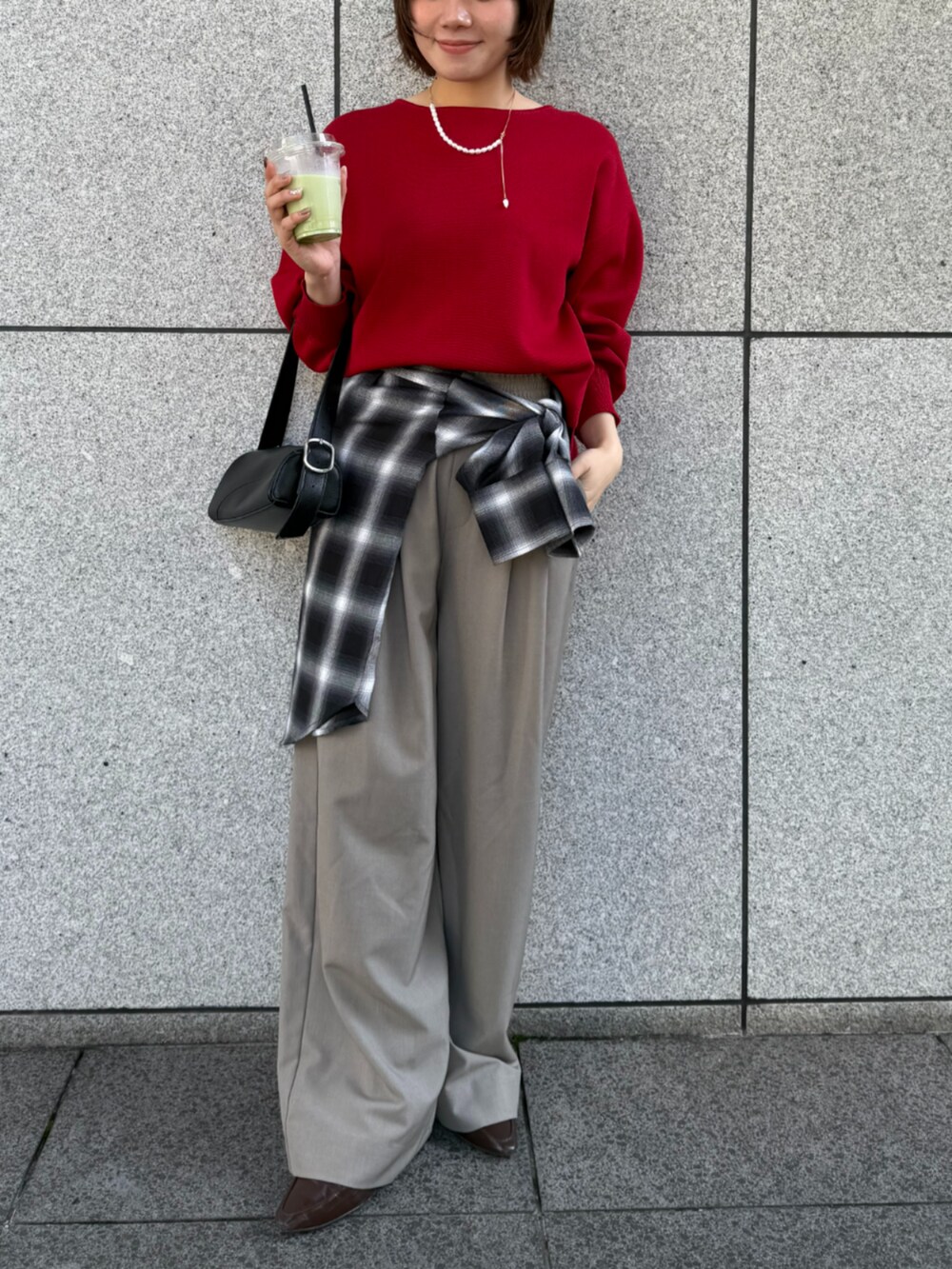 ベージュ系のスラックス、ブラック系のシャツ/ブラウス、レッド系のニット/セーターを着用したレディースの秋コーディネートの3枚目の写真