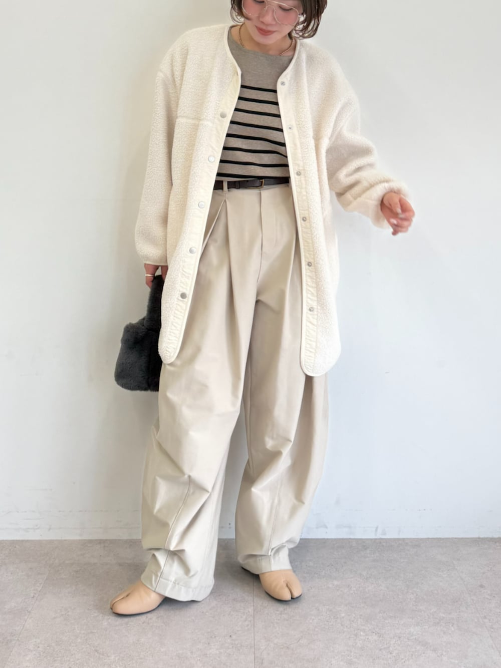 ベージュ系のその他パンツ、ホワイト系のノーカラーコート、ブラウン系のニット/セーターを着用したレディースの秋コーディネートの2枚目の写真