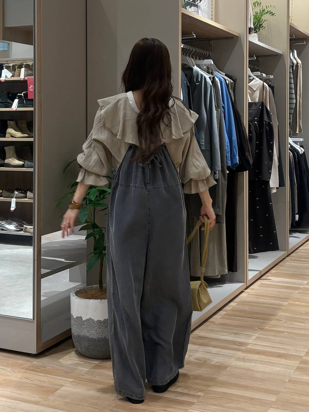 ブラック系のローファー、ベージュ系のショルダーバッグ、ブラック系のサロペット/オーバーオールを着用したレディースの春コーディネートの4枚目の写真