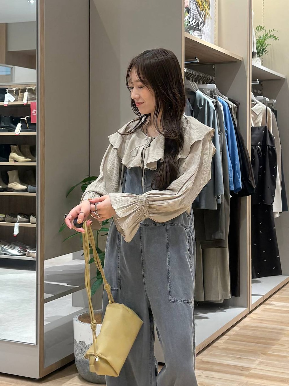 ブラック系のローファー、ベージュ系のショルダーバッグ、ブラック系のサロペット/オーバーオールを着用したレディースの春コーディネートの2枚目の写真