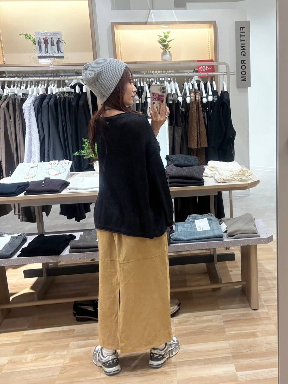 ブラック系のニット/セーター、ベージュ系のスカート、ブラック系のネックレスを着用したレディースの秋コーディネートの3枚目の写真