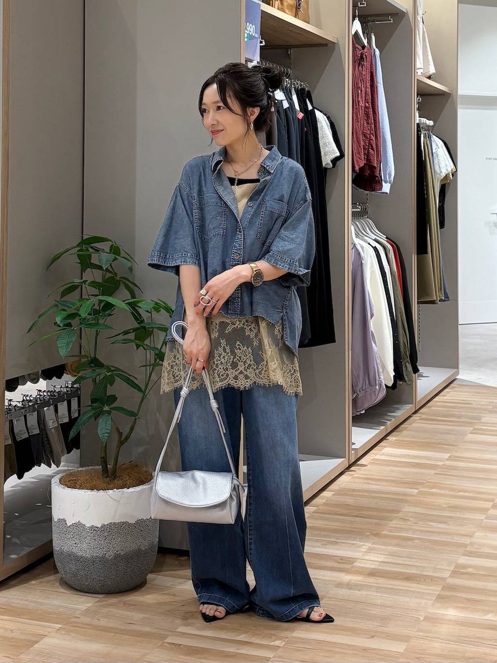 ブルー系のデニムパンツ、ブラック系のタンクトップ、ベージュ系のキャミソールを着用したレディースの夏コーディネートの5枚目の写真