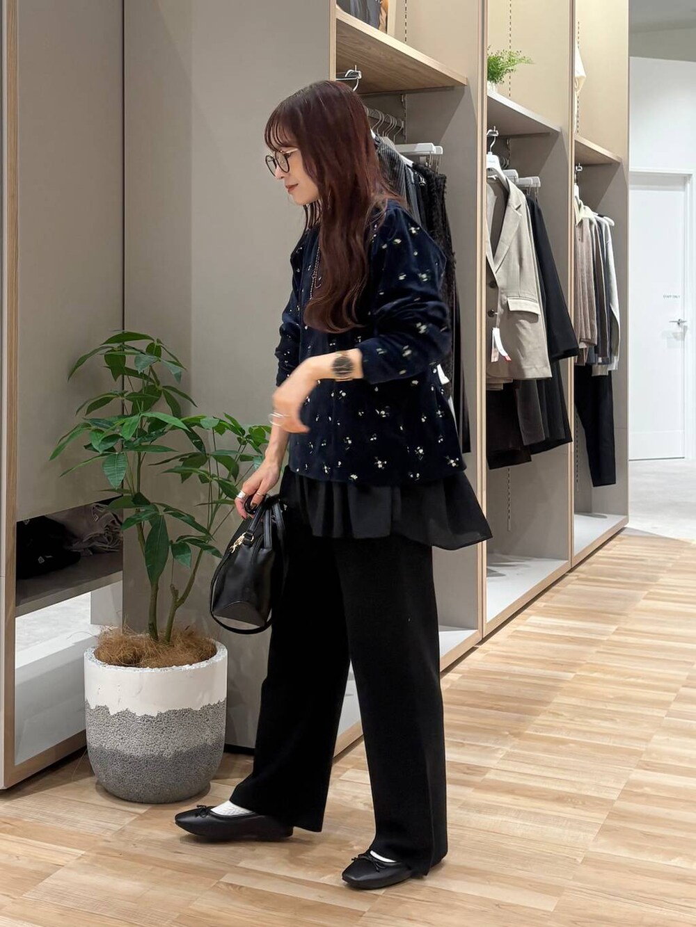 ブラック系のショルダーバッグ、ブラック系のTシャツ/カットソー、ブラック系のネックレスを着用したレディースの秋コーディネートの2枚目の写真