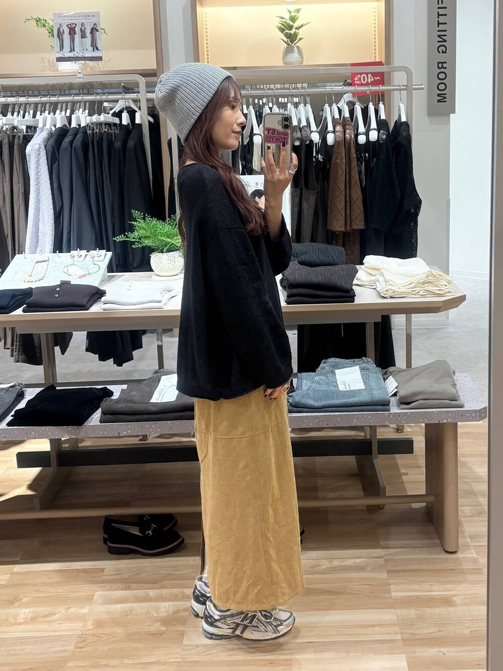 ブラック系のニット/セーター、ベージュ系のスカート、ブラック系のネックレスを着用したレディースの秋コーディネートの2枚目の写真