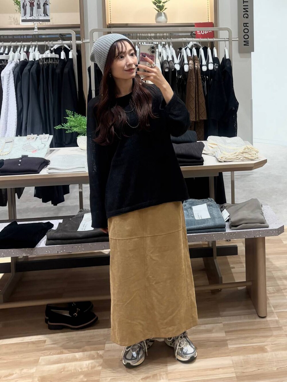 ブラック系のニット/セーター、ベージュ系のスカート、ブラック系のネックレスを着用したレディースの秋コーディネートの4枚目の写真