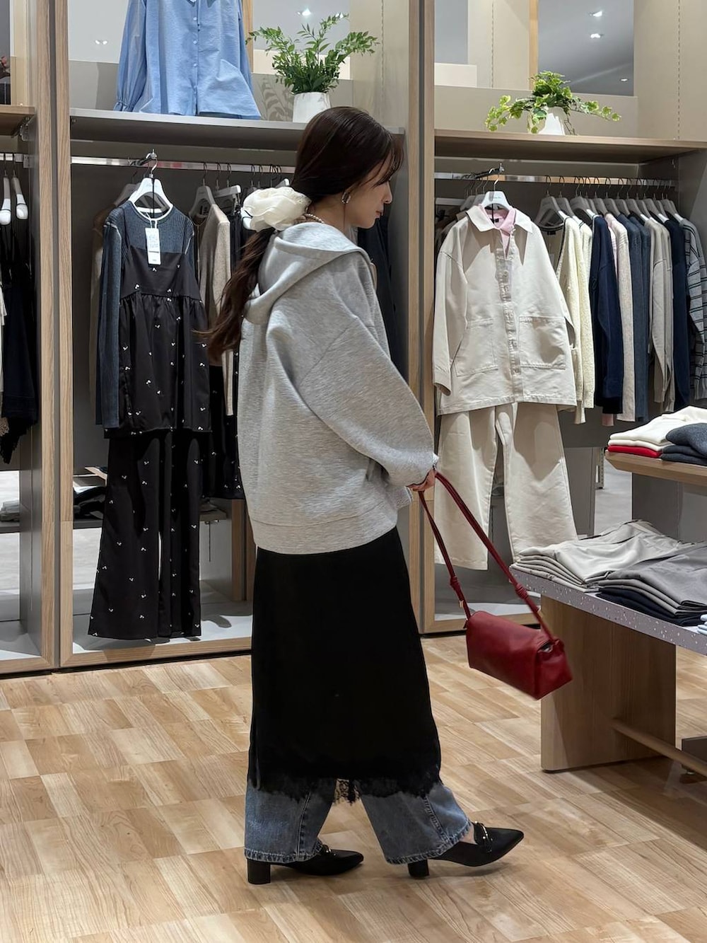 レッド系のショルダーバッグ、ブラック系のTシャツ/カットソー、ブルー系のデニムパンツを着用したレディースの春コーディネートの4枚目の写真