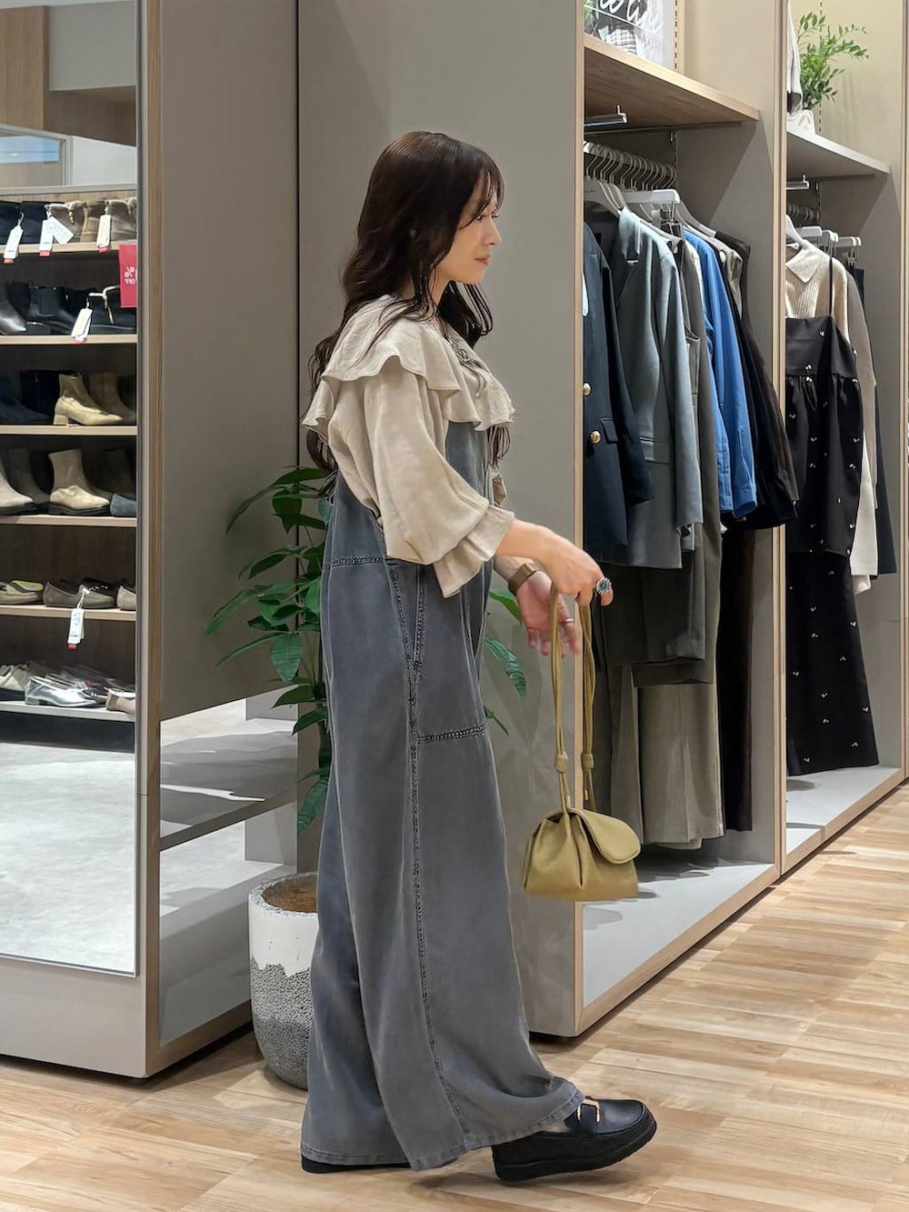 ブラック系のローファー、ベージュ系のショルダーバッグ、ブラック系のサロペット/オーバーオールを着用したレディースの春コーディネートの5枚目の写真