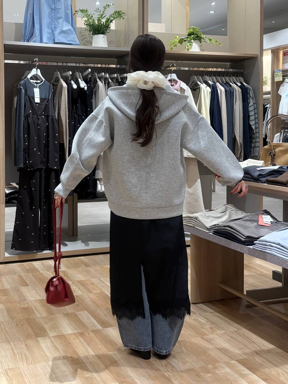 レッド系のショルダーバッグ、ブラック系のTシャツ/カットソー、ブルー系のデニムパンツを着用したレディースの春コーディネートの3枚目の写真